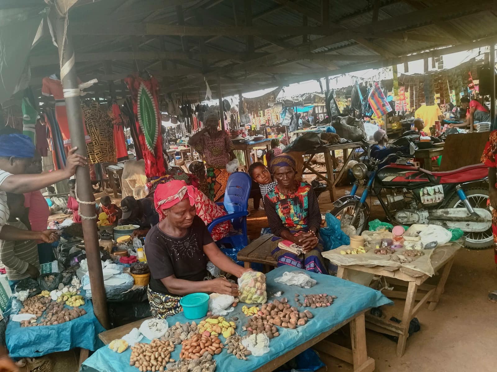Traders selling loose goods from open tables at a West African market